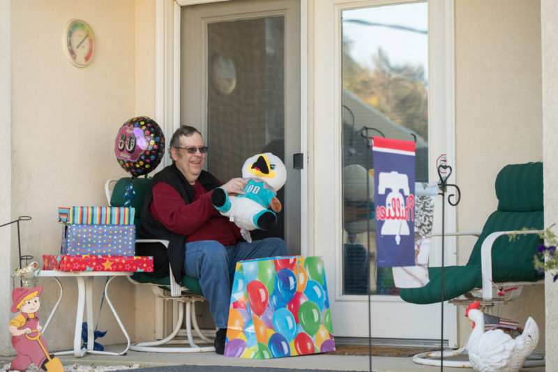 Male resident opening birthday gifts outside